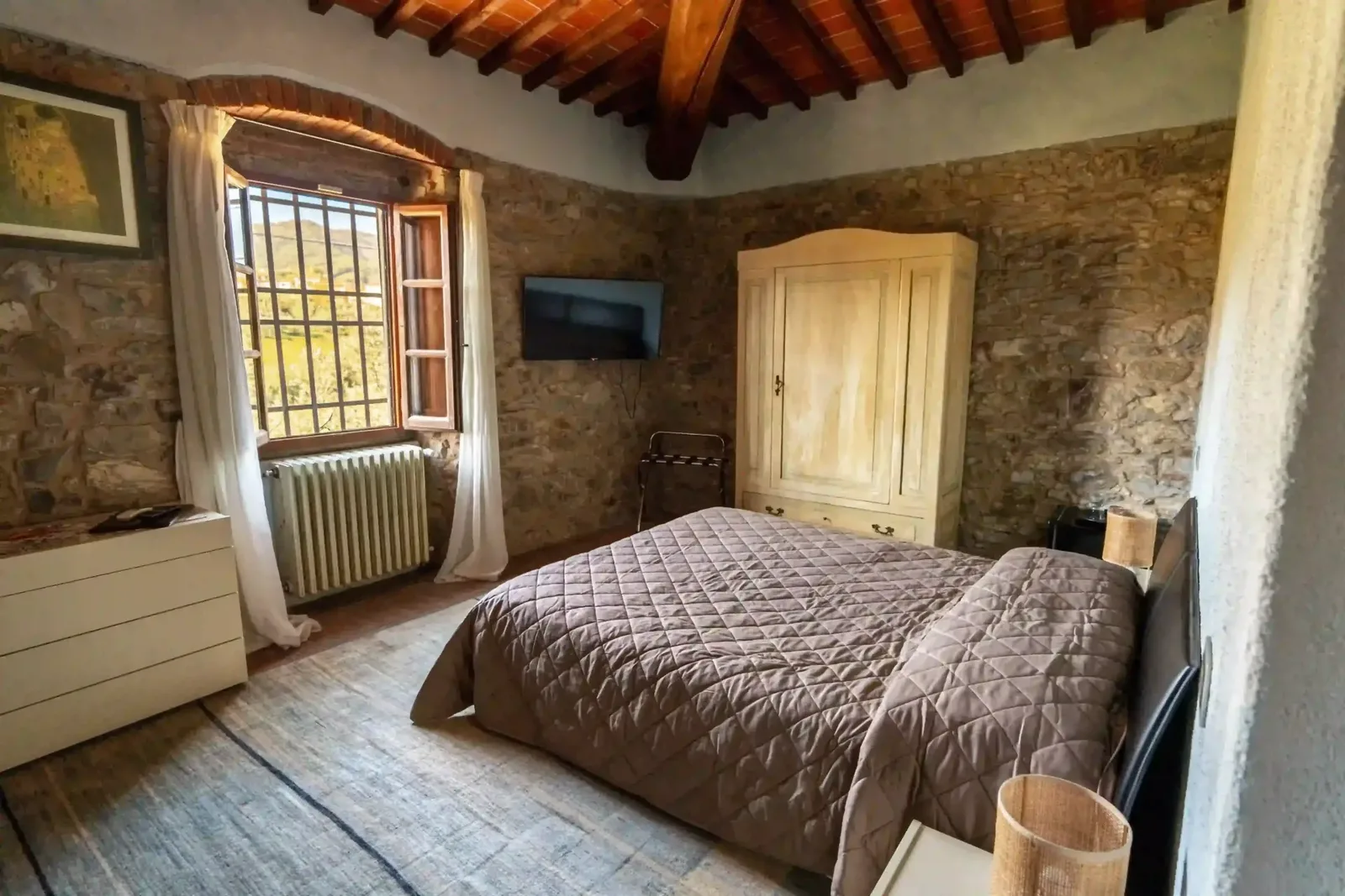 Camera dell'Agriturismo Sottotono con soffitto a travi in legno, fotografia d'interni Koral