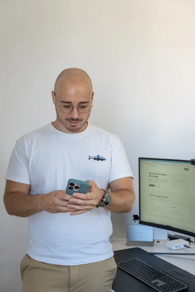 Francesco Nocentini in piedi che guarda il telefono nel suo studio