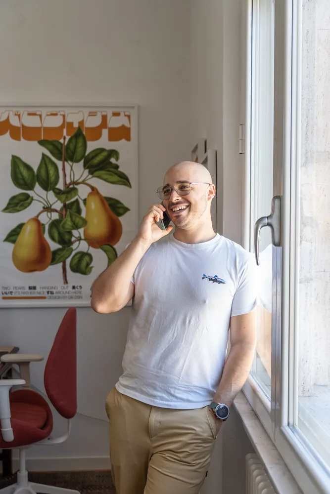 Francesco Nocentini al telefono vicino alla finestra, mentre ride