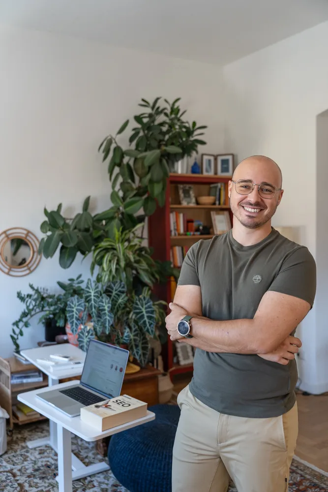 Francesco Nocentini in piedi a braccia conserte, con la postazione di lavoro e le piante alle spalle