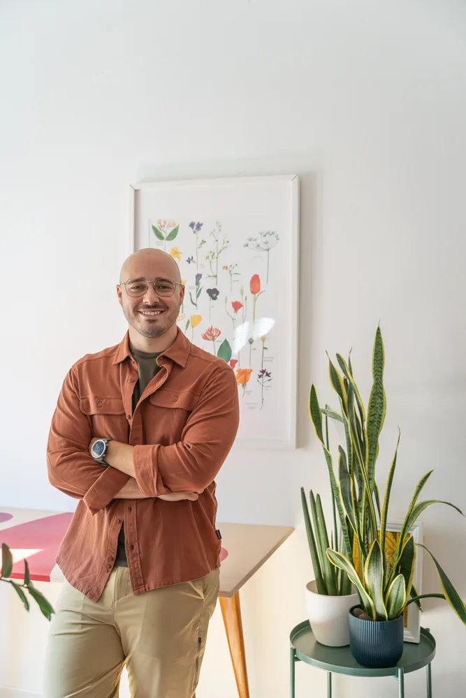 Francesco Nocentini in camicia, in piedi a braccia conserte accanto al tavolo di lavoro