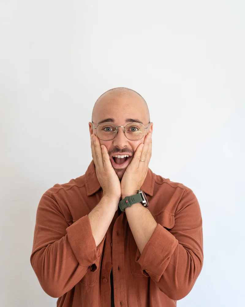 Francesco Nocentini con le mani sulle guance e l’espressione sorpresa, su fondo bianco