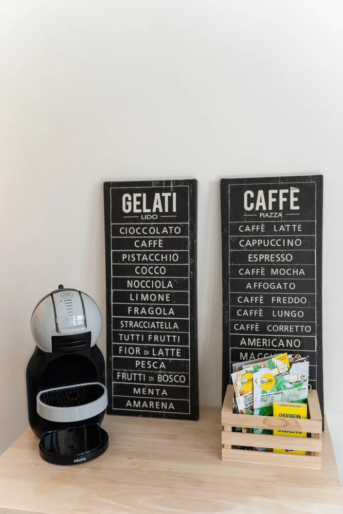 Angolo caffè con macchina a capsule e lavagnette dei gusti, a Le Mura 85