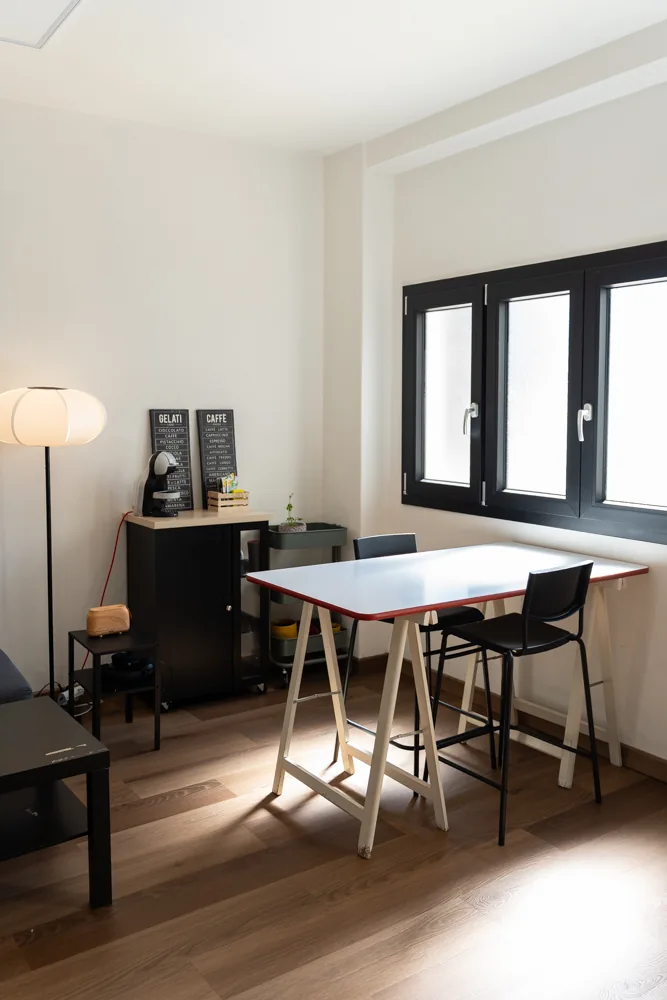 Postazione con tavolo alto e sedie accanto alle finestre della lounge