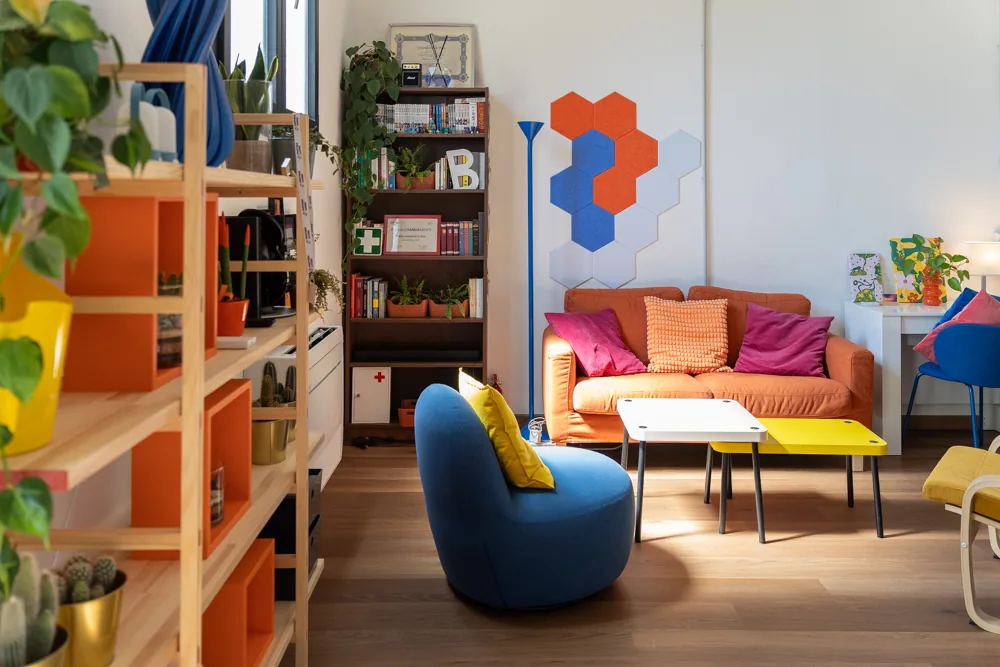 La lounge ripresa dal lato della libreria, con le piante in primo piano