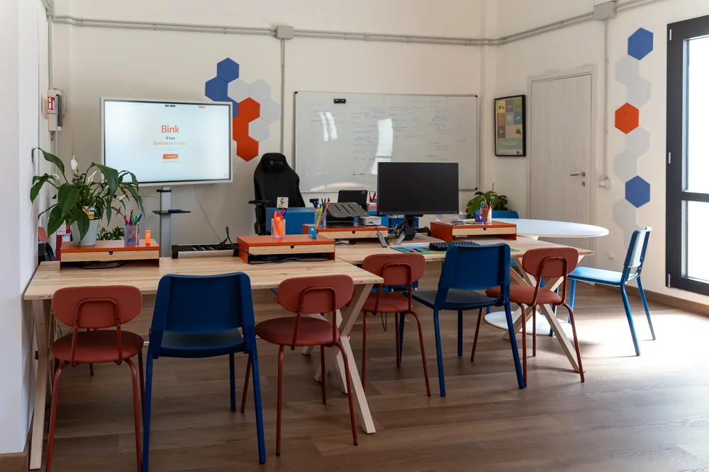 Vista d’insieme della sala corsi con i banchi e lo schermo acceso