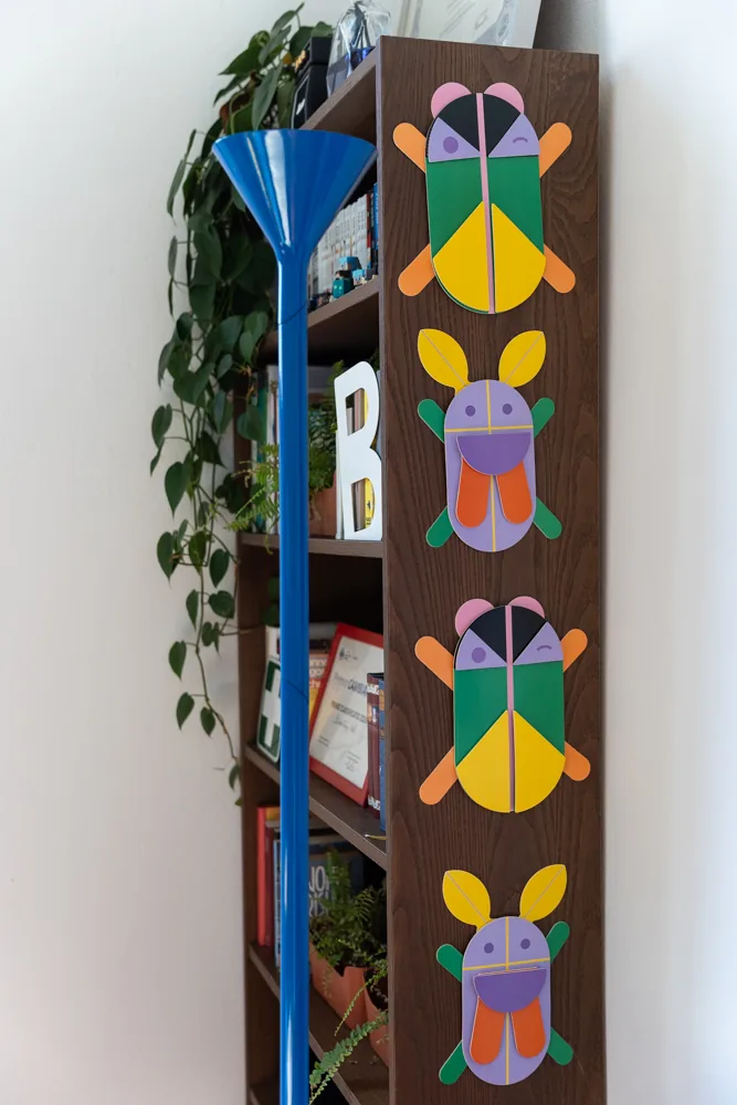 Libreria in legno scuro con il pannello illustrato e la lampada da terra blu