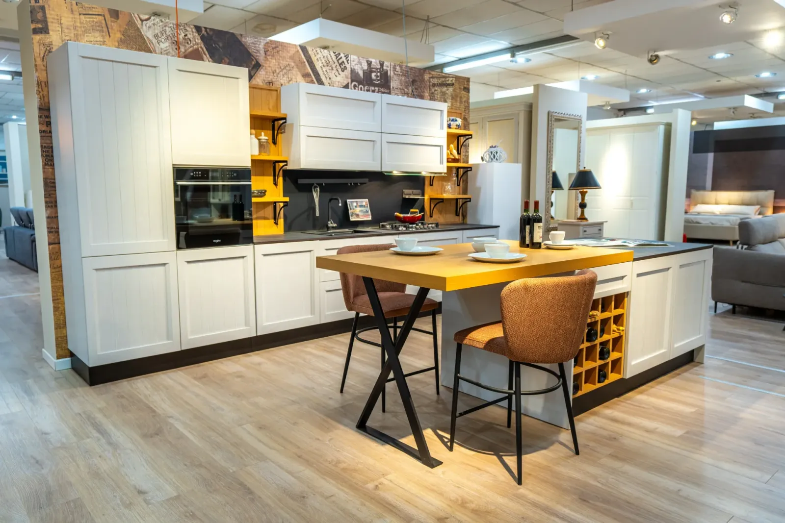 Cucina bianca con isola e piano in legno nello showroom Londi Arredamenti, fotografia Koral