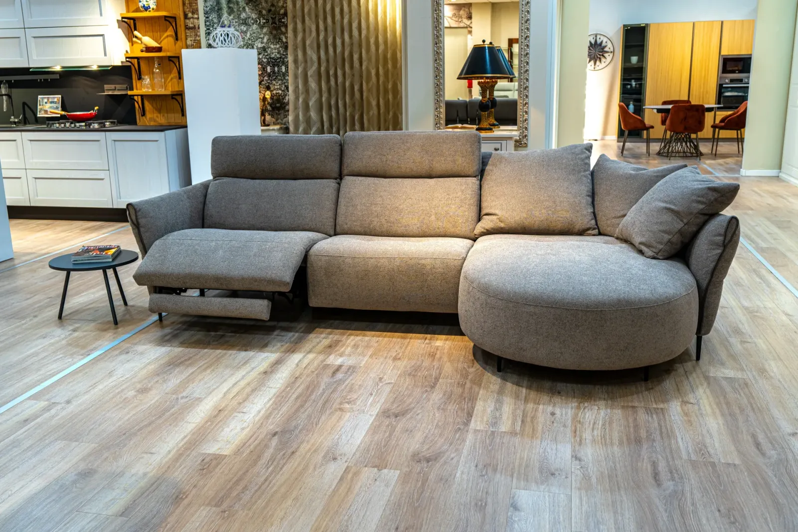 Divano angolare grigio con poggiatesta reclinabili nello showroom, scatto Koral