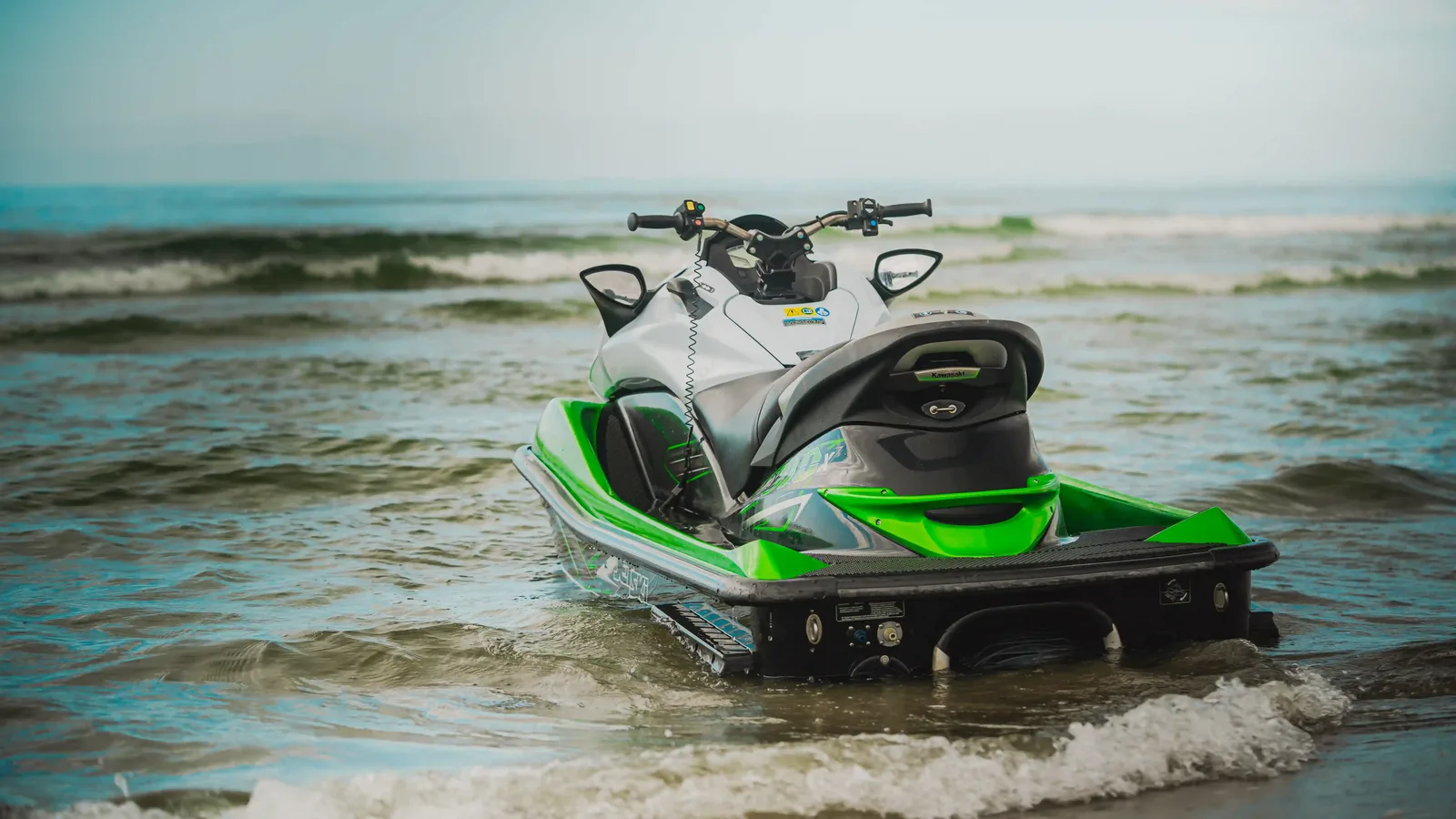 Moto d'acqua verde e nera fra le onde sulla spiaggia della Versilia, scatto Koral