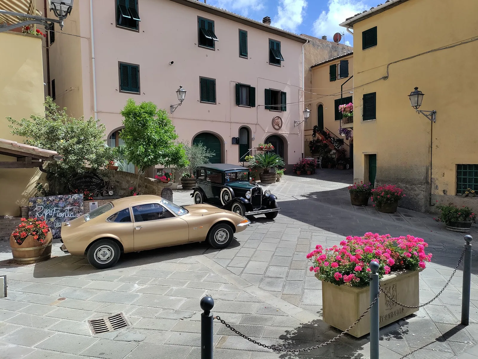 Piazza del Borgo di Sotto a Riparbella con auto d'epoca, immagine post-prodotta da Koral
